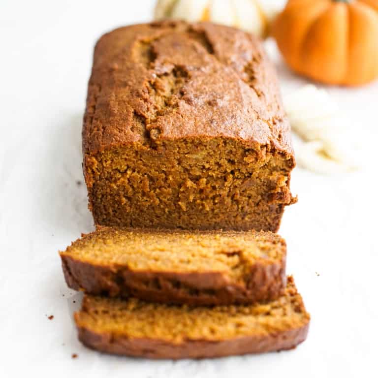 A loaf of moist and soft pumpkin banana bread sliced into a few slices