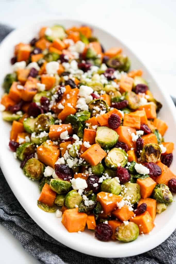 Closeup of a platter loaded with oven roasted Brussels sprouts and sweet potatoes