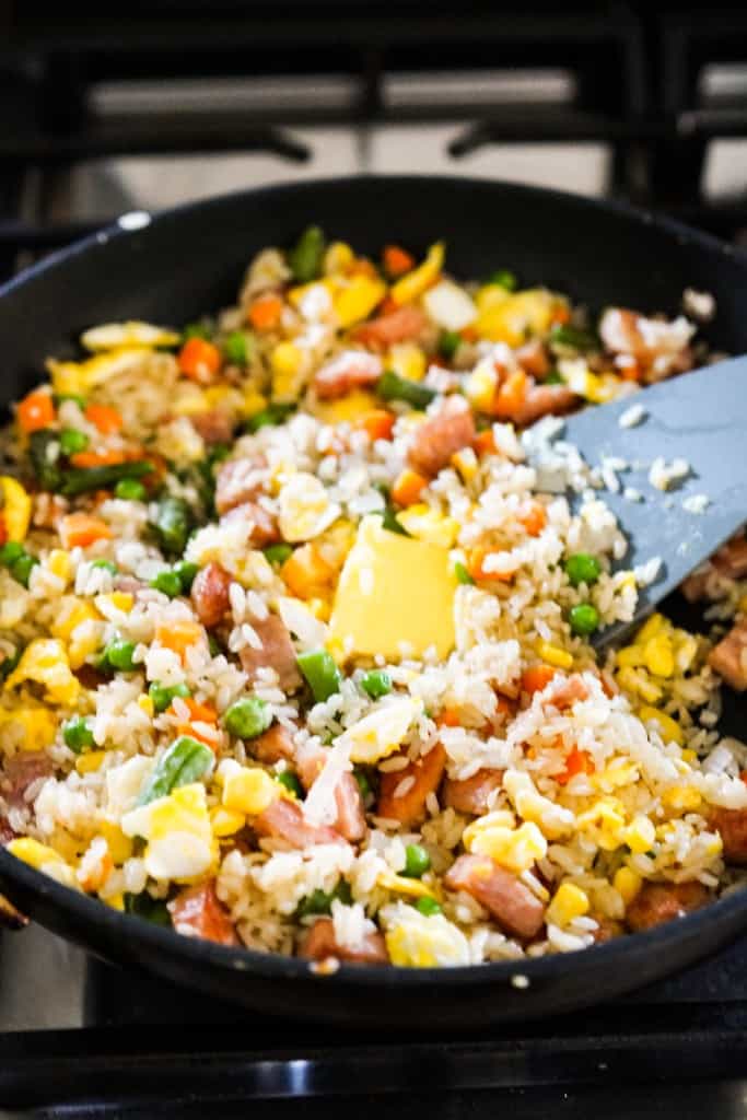 A small knob of butter in the spam fried rice in skillet
