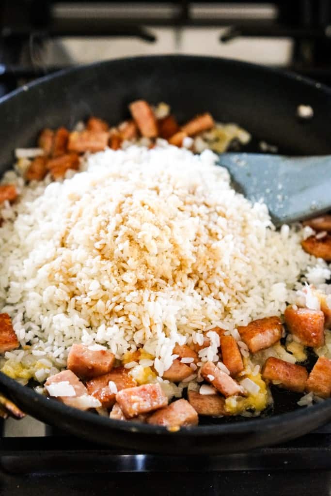 Adding rice to skillet with spam and onions