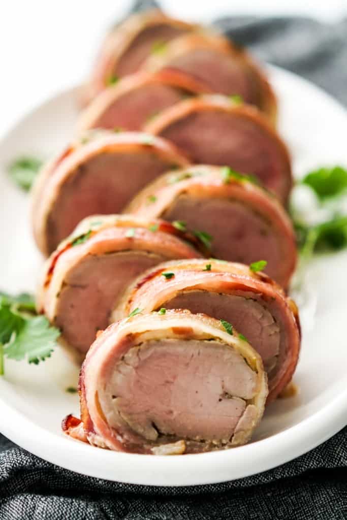 Closeup of slices of pork tenderloins rolled in bacon.