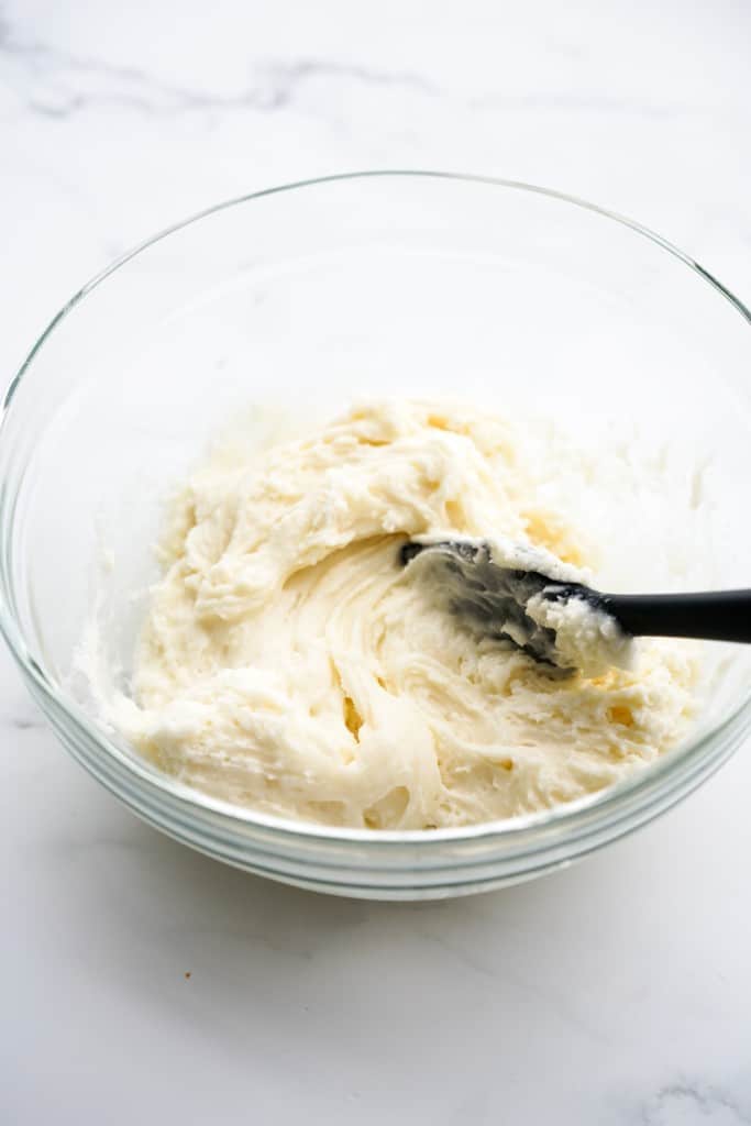 Cream cheese icing in a clear mixing bowl