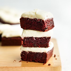 A stack of red velvet brownies with cream cheese icing