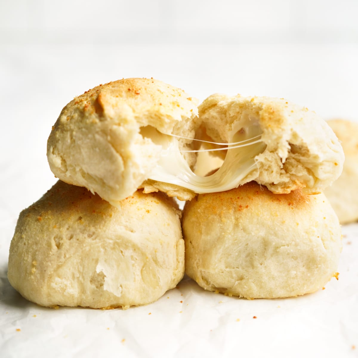 Cheese oozing out of dinner rolls that were broken into two
