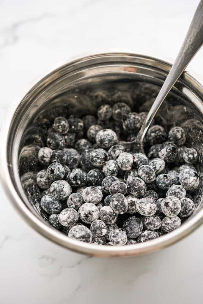 Fresh blueberries in a mixing bowl coated in flour