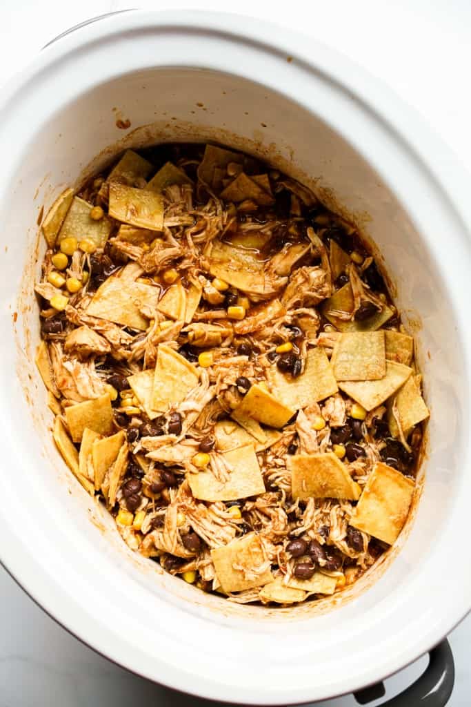 Shredded chicken, black beans, corn and cubed tortillas in a slow cooker