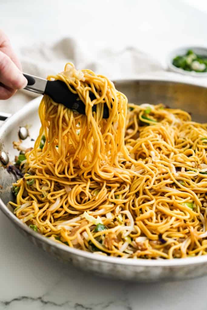 Lifting chow mein noodles from a skillet