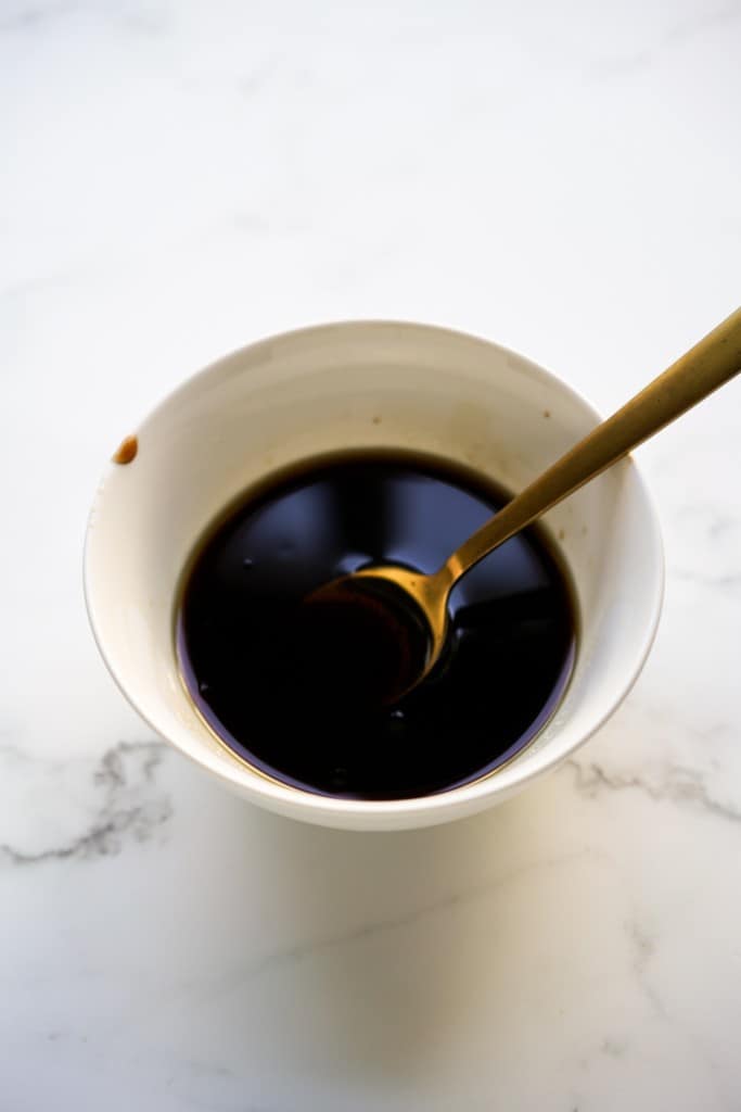 A bowl of sauce with a spoon in it