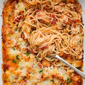Chicken spaghetti in red sauce baked in the oven topped with cheese