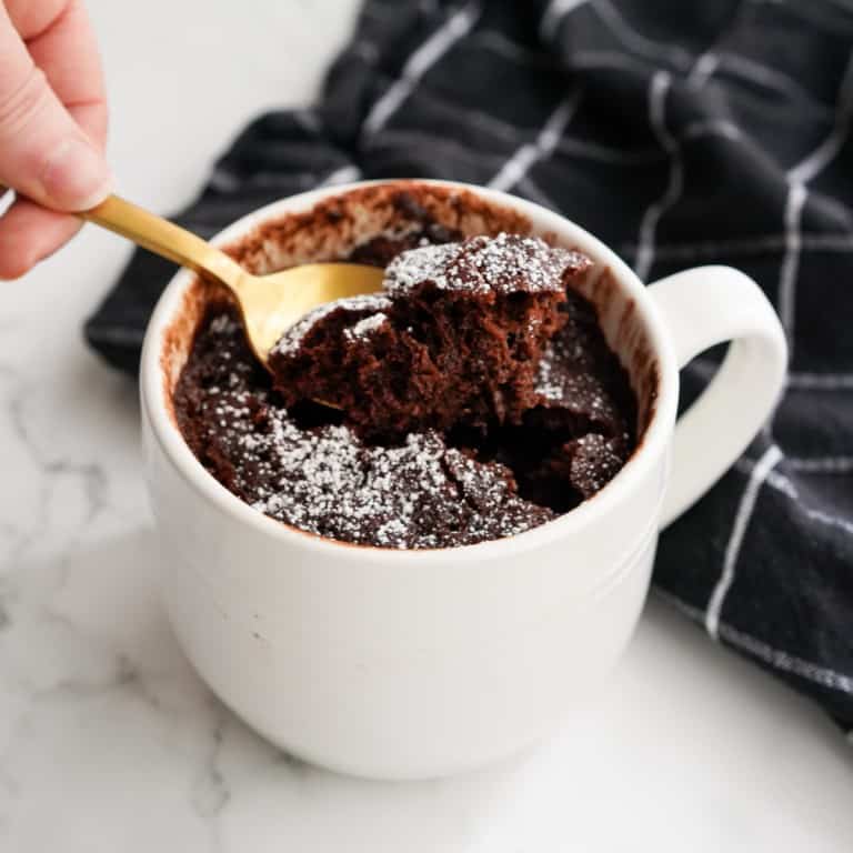 Scooping out some chocolate cake in a mug