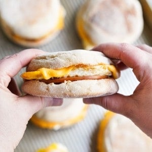 Holding an english muffin breakfast sandwich with egg, cheese and Canadian bacon