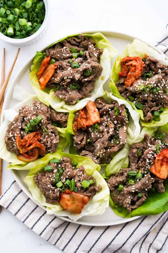 Top down view of a bunch of Korean beef lettuce wraps in a large round plate