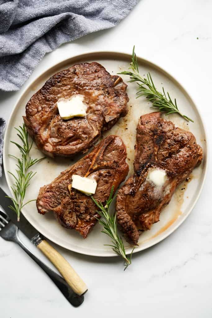 Top down view of a round plate of three lamb chops 