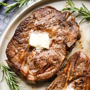 A piece of bone in lamb chops topped with melted butter
