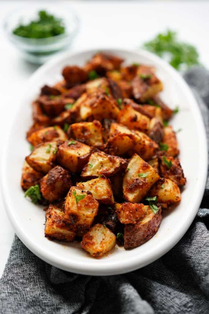 A plate full of crispy garlic roasted parmesan potatoes 