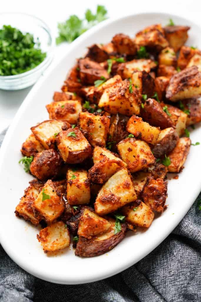 A plate loaded with garlic parmesan roasted potatoes