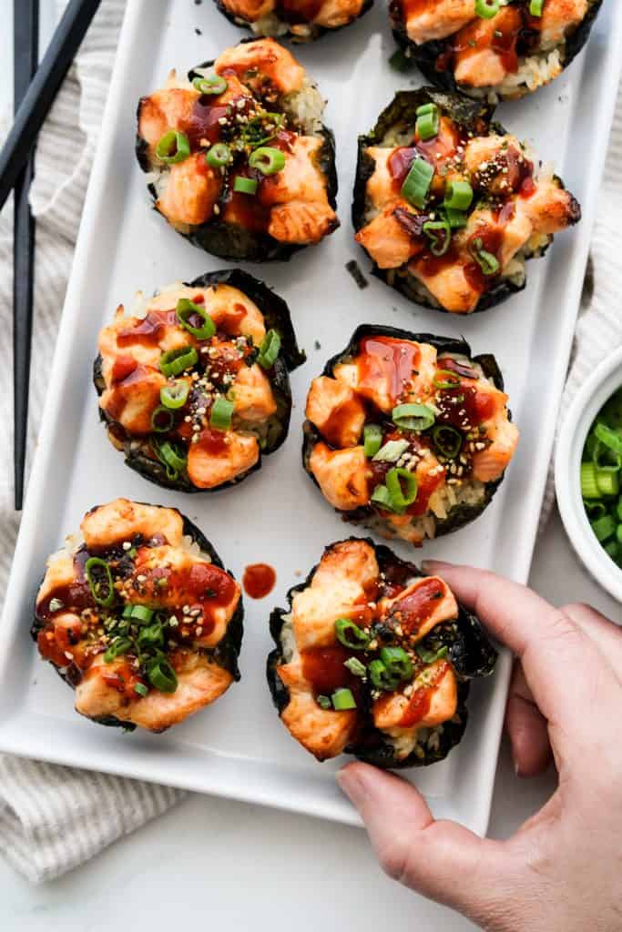 A plate of sushi cups topped with baked salmon, along with furikake and chopped green onions