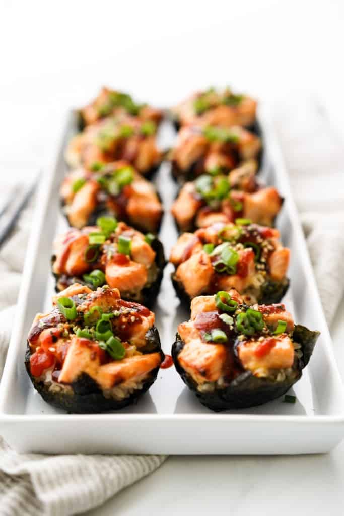 Salmon sushi cups lined up on a platter