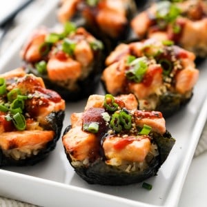 salmon sushi cups wrapped in seaweed, topped with salmon cubed, green onions and furikake