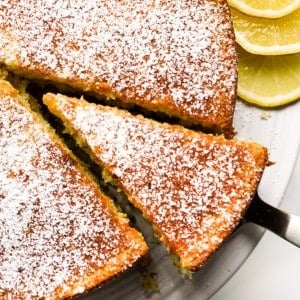 Lifting out a triangular slice of round lemon olive oil cake