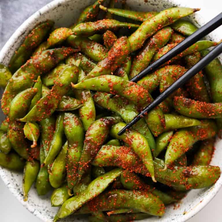 A bowl of spicy garlic edamame topped with togaroshi