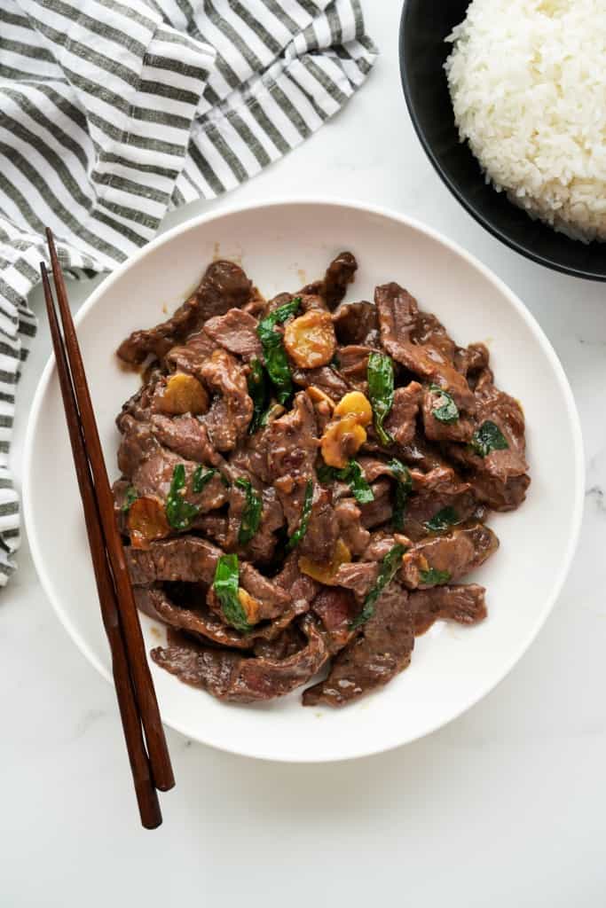 A plate of ginger scallion beef with white rice on the side