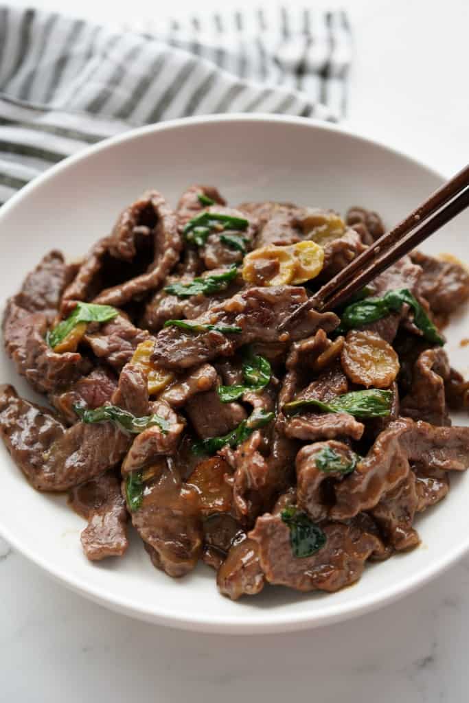 A large plate of stir fry beef with ginger and scallions