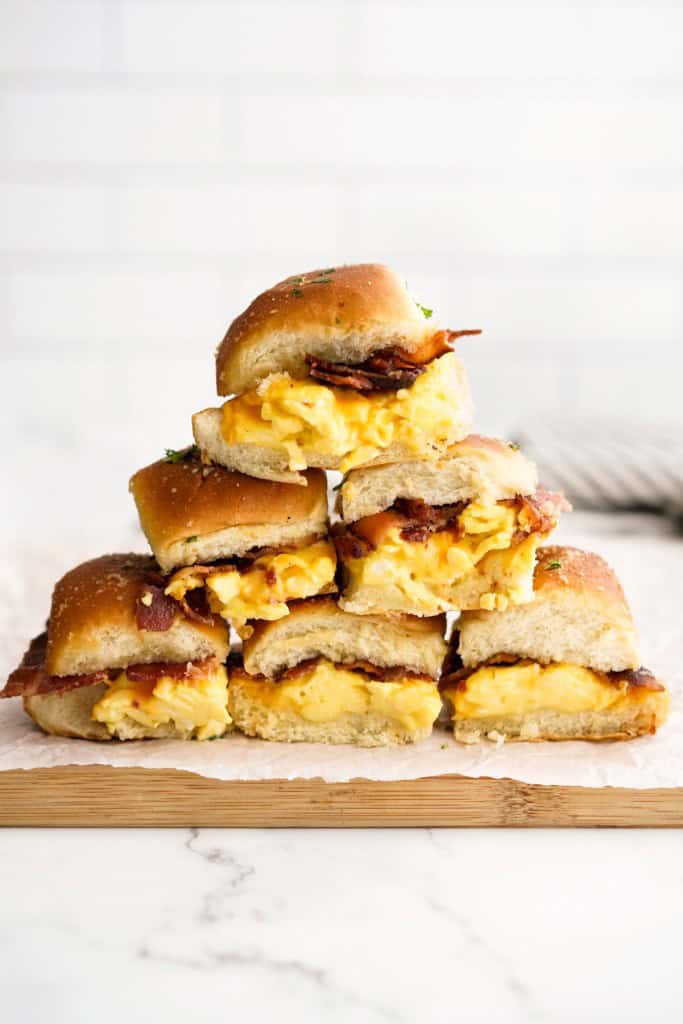 Breakfast sliders in hawaiian rolls stacked on top of each other to make a shape of a pyramid