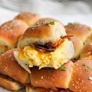 A hamburger slider filled with scrambled eggs, bacon and cheese.
