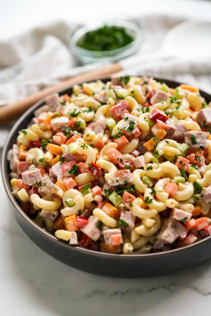 A bowl of macaroni ham salad tossed in creamy dressing