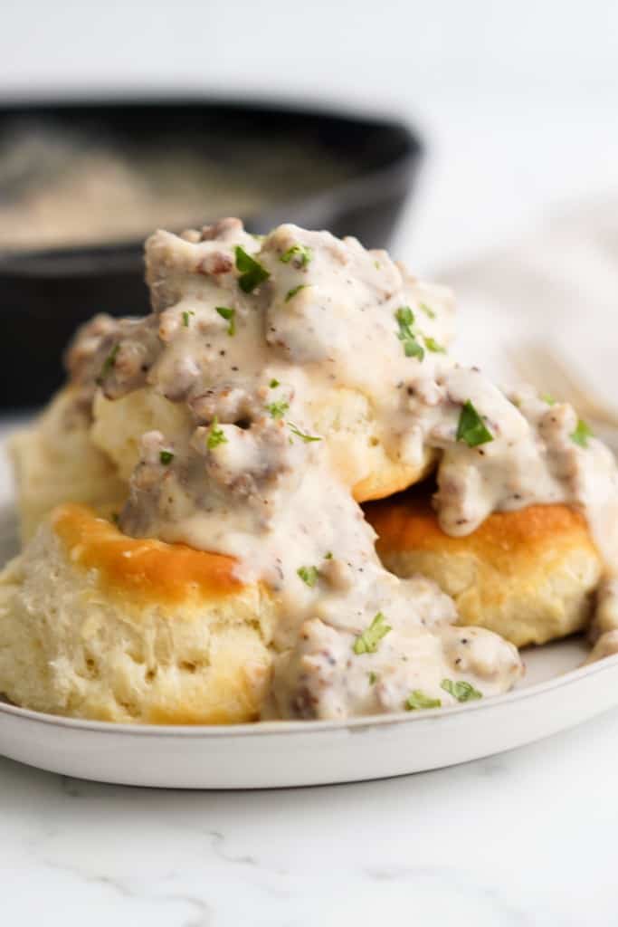 Closeup of sausage gravy smothered over biscuits
