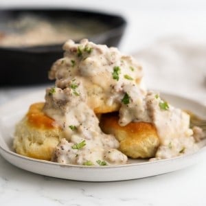 A stack of biscuits topped with creamy sausage gravy