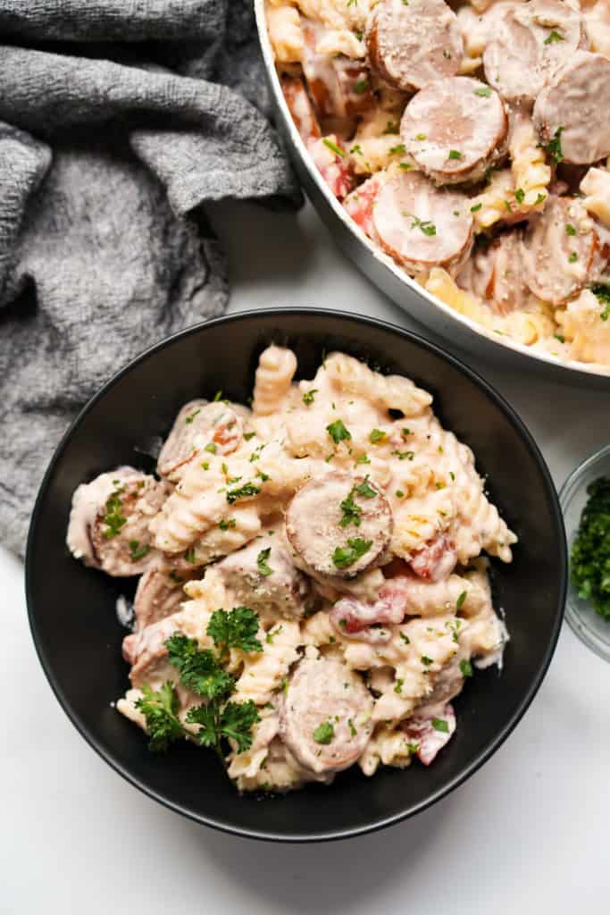Serving creamy smoked sausage pasta in a bowl
