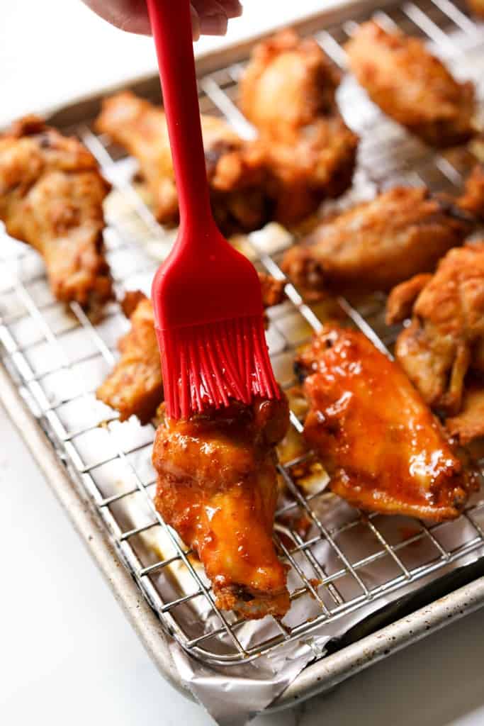 Brushing crispy wings with hot honey glaze