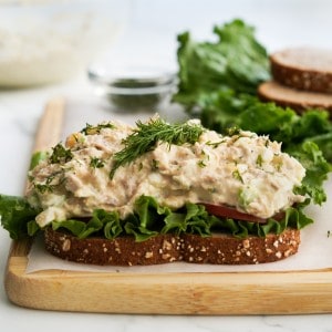 Tuna egg salad on top of a piece of bread lined with green lettuce