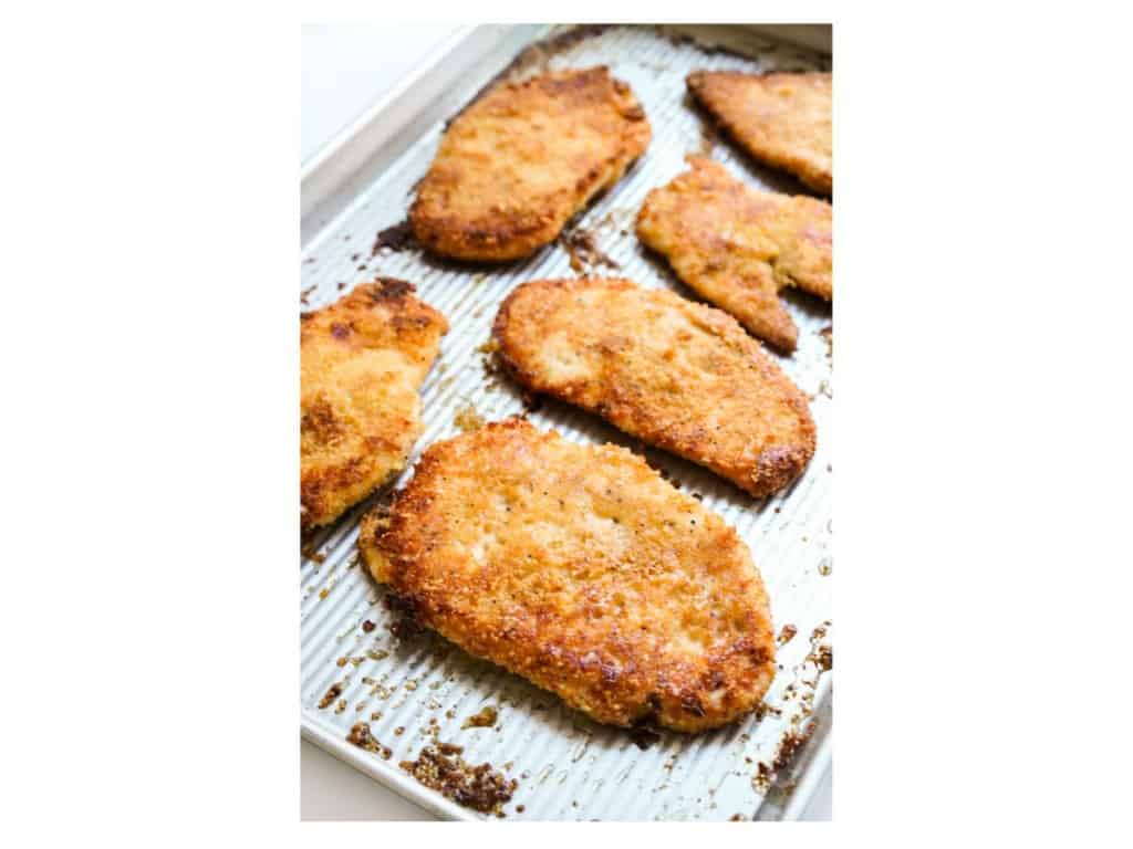 Crispy baked chicken cutlets on a baking sheet right out of the oven