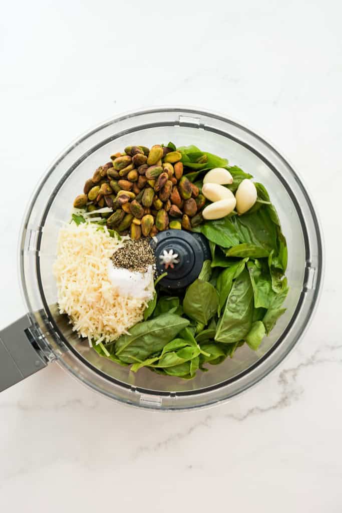 Fresh basil leaves, grated parmesan, shelled pistachios, garlic cloves, salt and black pepper in a food processor