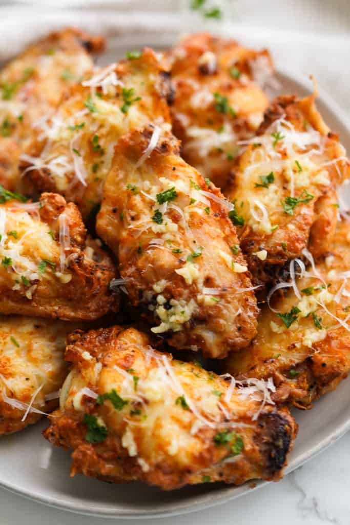 Closeup of crispy garlic parmesan chicken wings topped with parmesan and parsley