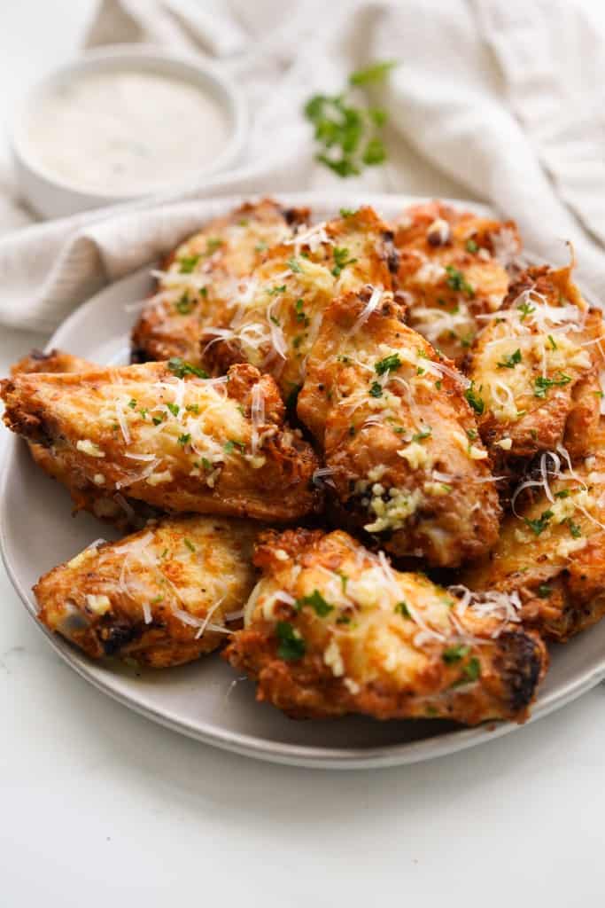 A plate loaded with garlic parmesan wings