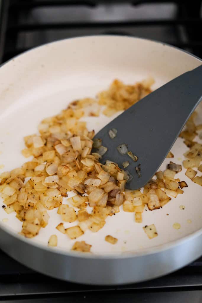 Searing diced onions until they turning soft and brown