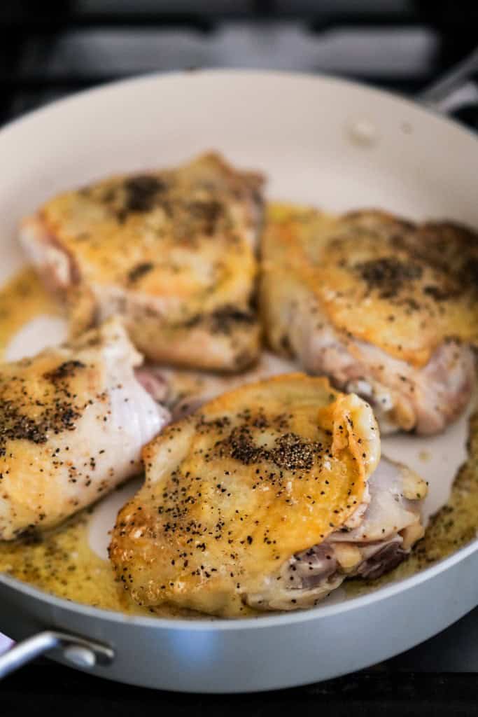 Searing bone-in, skin-on chicken thighs in the skillet