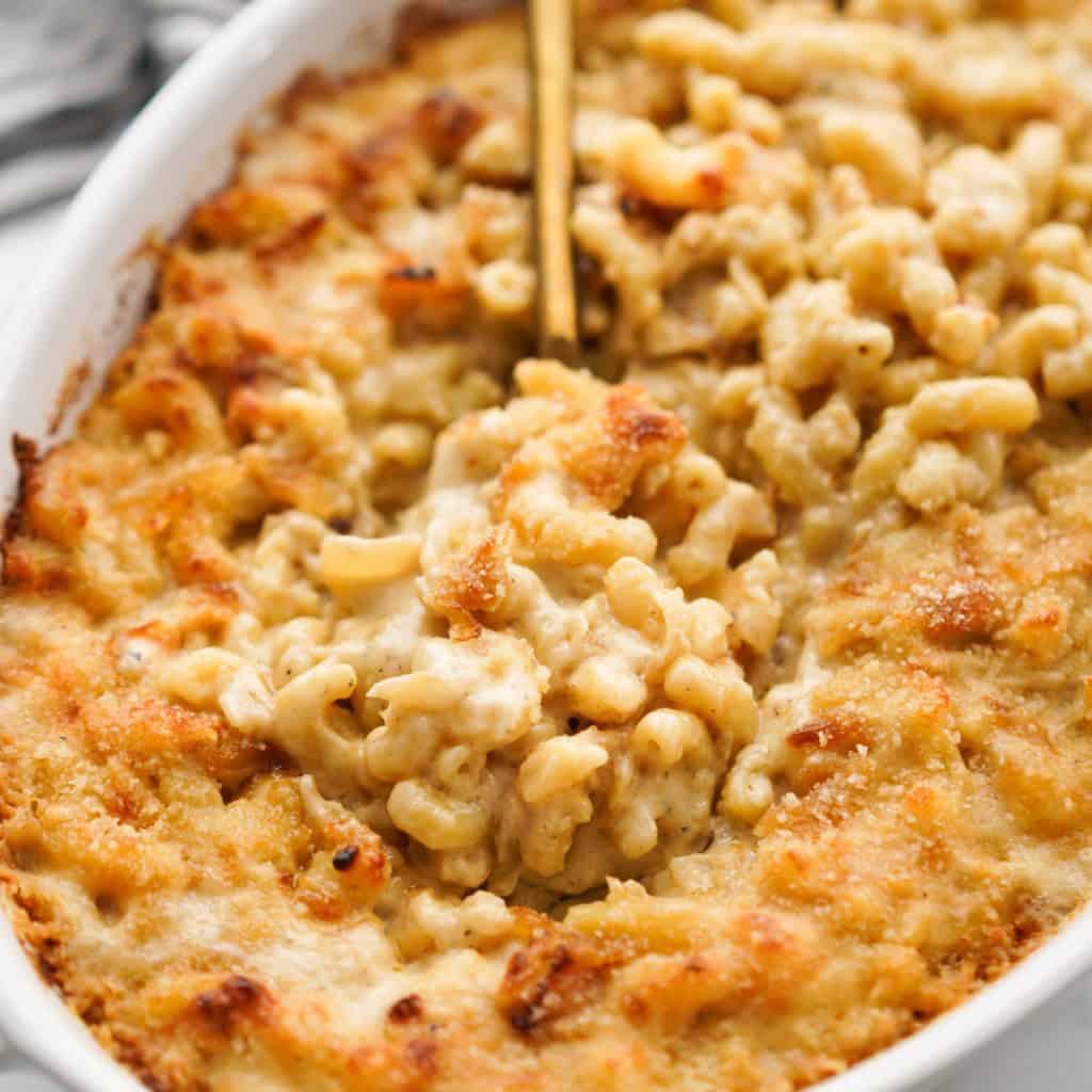 Using a gold spoon to scoop cheesy mac and cheesy