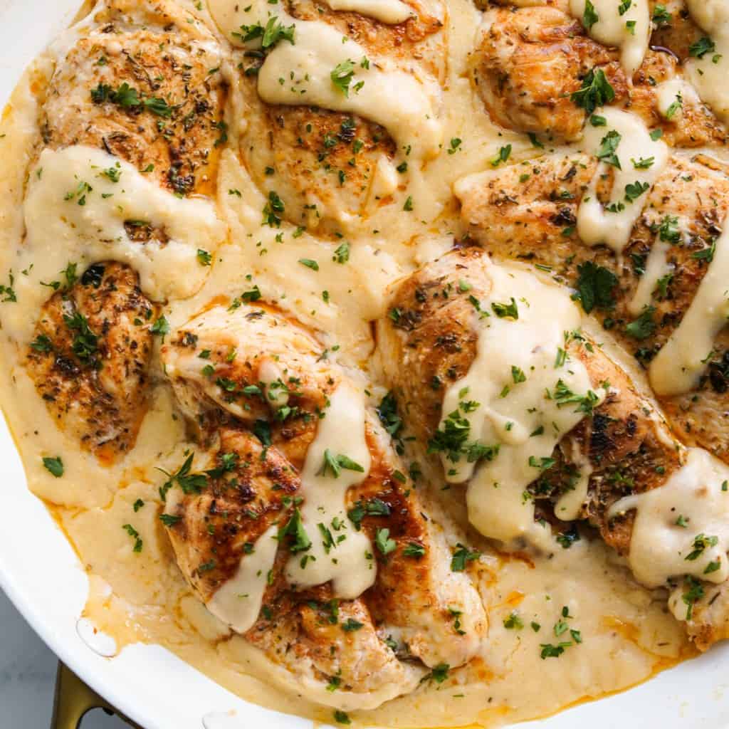 pan seared garlic herb chicken in creamy sauce in a skillet