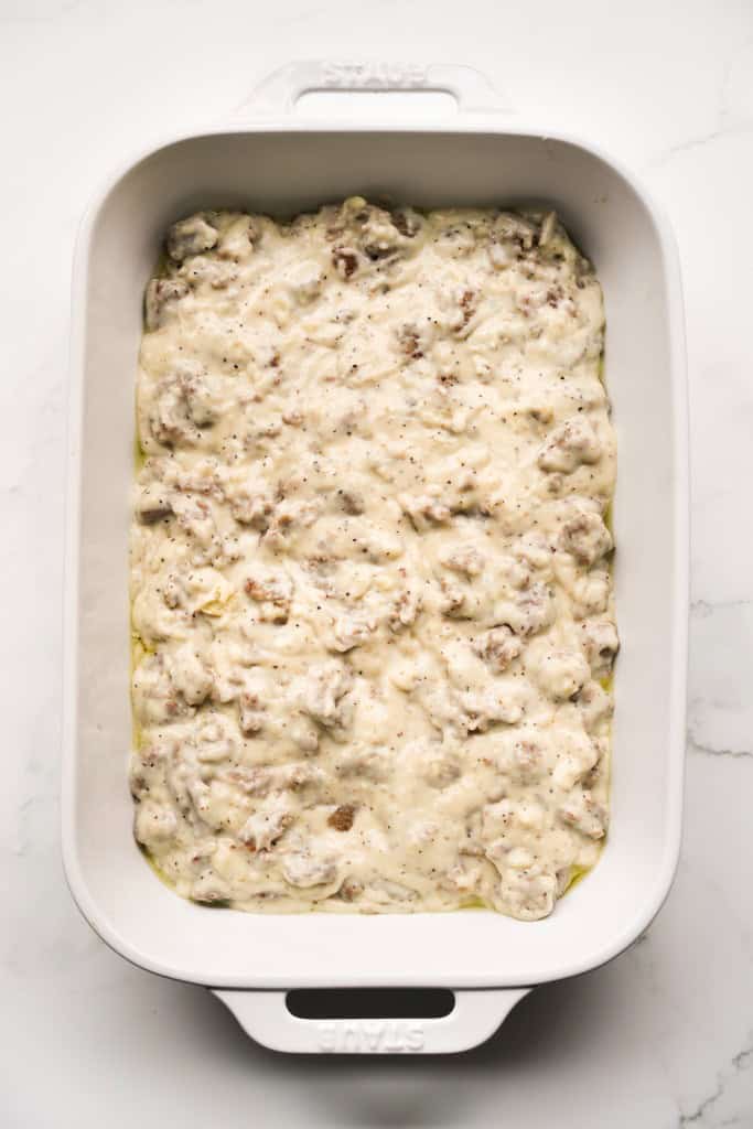 Sausage gravy spread out on a rectangular casserole dish