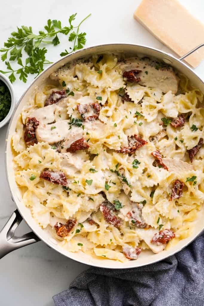 A large pot of sundried tomato pasta tossed in creamy sauce