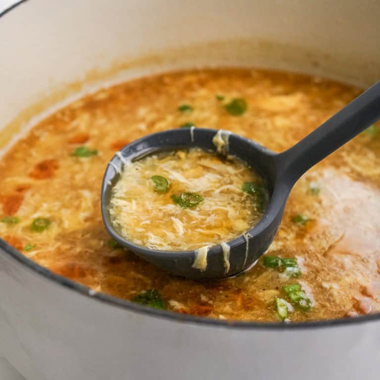 Scooping up egg drop soup from a pot with a ladle
