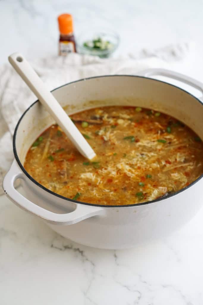 A large pot of hot and sour soup with egg strands