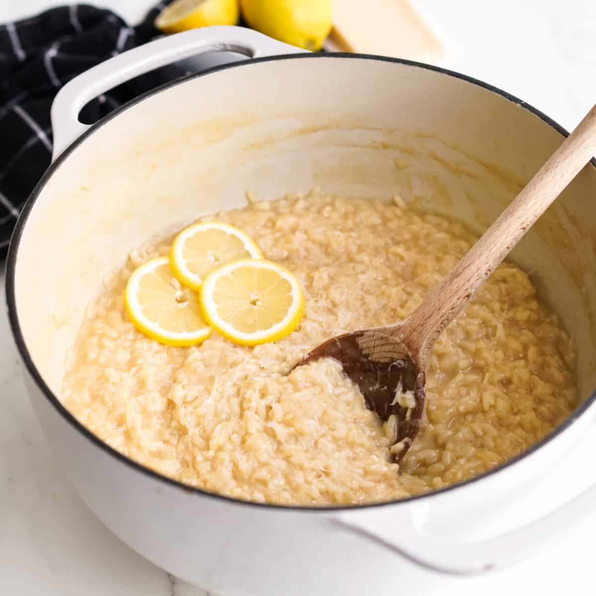 A pot of lemon risotto topped with lemon slices