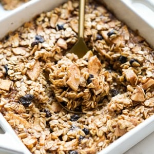 Digging into a square dish of baked oatmeal with apples