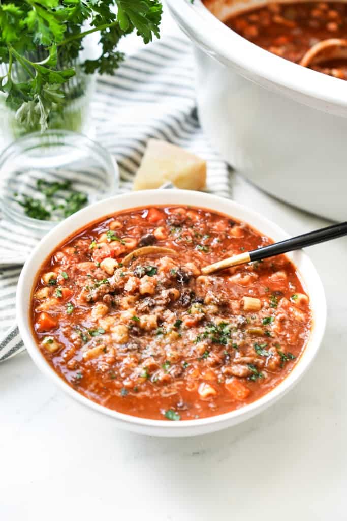 A bowl of pasta fagioli in front of the crockpot